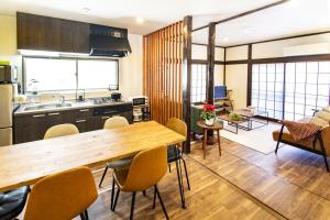 a kitchen and living room with a wooden table and chairs at MIYABI Tateishi in Tokyo