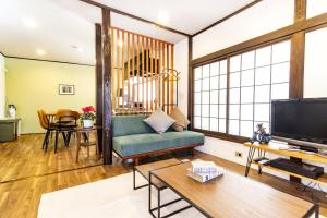 a living room with a couch and a tv at MIYABI Tateishi in Tokyo