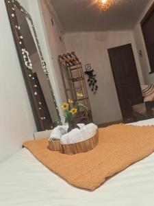 a wooden tray with towels and flowers on a bed at Aconchego Suíte in Prado