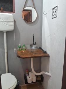 a bathroom with a sink and a mirror at Aconchego Suíte in Prado