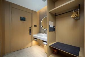 a bathroom with a sink and a mirror at Atour Hotel Suzhou Mudu Shoutao Lake in Suzhou