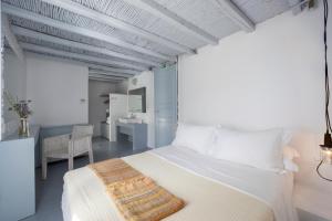 a bedroom with a white bed and a desk at Coco-Mat Eco Residences Serifos in Vayiá