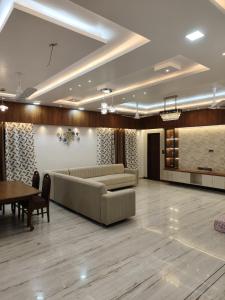 a living room with couches and a table in a room at Luxurious 2 BHK Apartment - Home away from Home ! in Udaipur