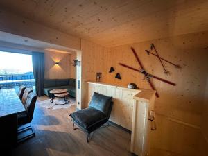 a living room with a clock on the wall at Chalet-Style Apartment Sonnleitn Nassfeld in Hermagor