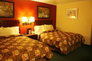 a hotel room with two beds and two lamps at Relax Inn Chehalis in Chehalis