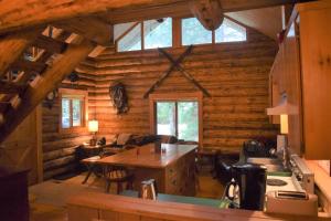 a kitchen and living room in a log cabin at Cascade Log Cabin | Mt Rainier, WIFI, Log Cabin in Packwood