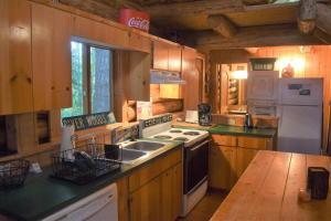 a kitchen with wooden cabinets and a stove top oven at Cascade Log Cabin | Mt Rainier, WIFI, Log Cabin in Packwood