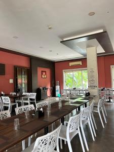 a dining room with a long table and white chairs at Ivy Bliss Studio with Common Pool, B 14, Karjat in Karjat