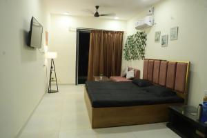 a bedroom with a bed and a television in it at Ivy Bliss Studio with Common Pool, B 14, Karjat in Karjat +31 photos