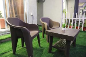 three chairs and a table in a room with grass at Ivy Bliss Studio with Common Pool, B 14, Karjat in Karjat