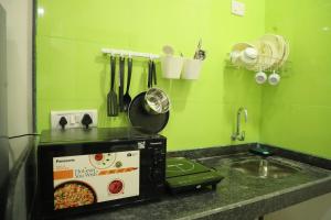 a kitchen counter with a sink and a microwave at Ivy Bliss Studio with Common Pool, B 14, Karjat in Karjat