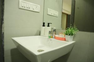 a white sink in a bathroom with a mirror at Ivy Bliss Studio with Common Pool, B 14, Karjat in Karjat