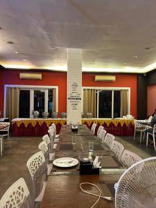 a dining room with a long table and white chairs at Ivy Bliss Studio with Common Pool, B 14, Karjat in Karjat