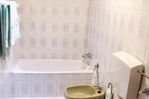 a bathroom with a tub and a green toilet at Charming House in Paredes do Rio with Mountain View in Paredes do Rio