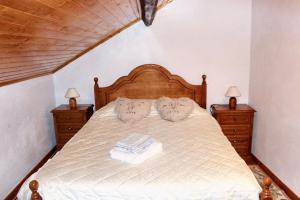 a bedroom with a bed with two dressers and two lamps at Charming House in Paredes do Rio with Mountain View in Paredes do Rio