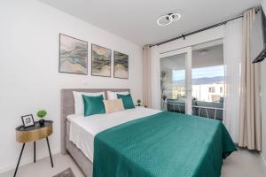 a bedroom with a bed and a large window at Apartments Olive Gardens 2 in Novalja