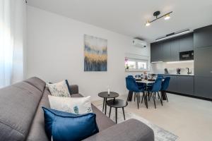 a living room with a couch and a dining room at Apartments Olive Gardens 2 in Novalja