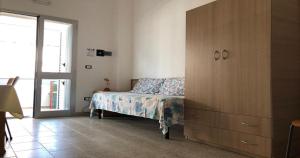 a bedroom with a bed and a wooden dresser at Odegos Residence Torre dell'Orso in Torre dell'Orso