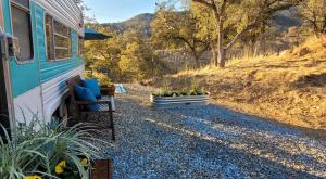 an rv parked on the side of a gravel road at Cozy Farm Stay for Two in Three Rivers
