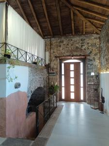 an indoor hallway with a staircase and a brick wall at Villa Alessio - Etna Historic Winery Villa - Ancient Palmento with pool in Puntalazzo