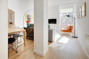una sala de estar blanca con mesa y sillas en Simone by FeelFree Rentals, en San Sebastián