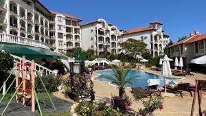 a resort with a swimming pool and some buildings at Triumph Holiday Village in Sveti Vlas