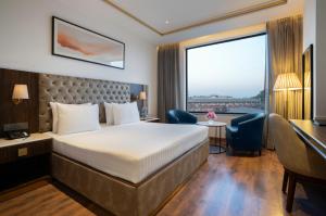 a hotel room with a bed and a desk at Clarks Inn Dehradun in Dehradun +15 photos