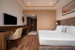 a hotel room with a bed and a desk at Clarks Inn Dehradun in Dehradun