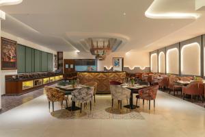 a restaurant with tables and chairs in a room at Clarks Inn Dehradun in Dehradun