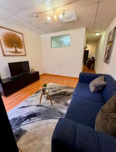 Una sala de estar con un sofá azul y un televisor. en Colosseum Apartments, en Johannesburgo