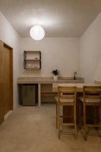 a kitchen with a table and chairs and a sink at Casa Tonalli in Jocotepec +12 photos