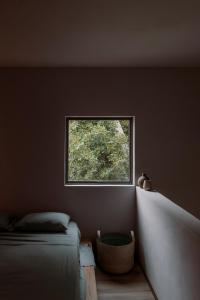 a small window in a room with a bed at Casa Tonalli in Jocotepec