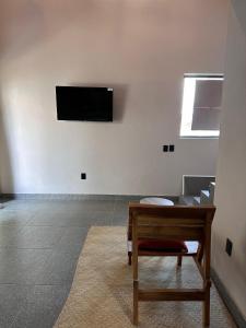 a room with a table and a television on a wall at Casa Tonalli in Jocotepec