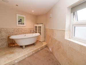 a bath tub in a bathroom with a window at Homestead in Chapel en le Frith +33 photos