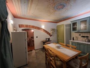 a kitchen with a table and a refrigerator at Casa Dipinta in Cairo Montenotte