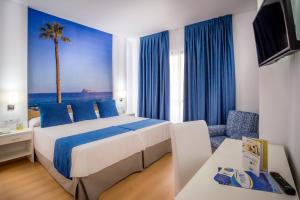a hotel room with a bed and a palm tree at Hotel Avenida in Benidorm