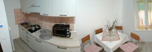 a kitchen with a sink and a table with a table at Loreal 1 in Castello Tesino