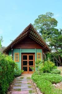 a small green house with a wooden door at Rawi Seaside Cottage, Ko Yao Noi in Ban Laem Sai
