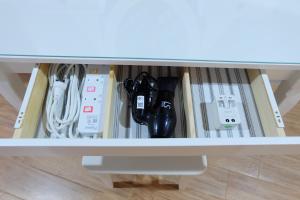 a drawer in a table with consoles and controllers at Rawi Seaside Cottage, Ko Yao Noi in Ban Laem Sai