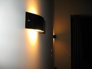 eine Lampe an einer Wand mit einem Fernseher darauf in der Unterkunft Argolis Hotel in Nafplio