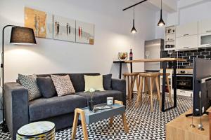 Una sala de estar con un sofá y una cocina. en Old town, Splantzia modern house, en La Canea