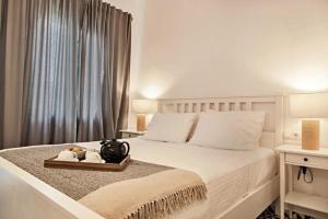 1 dormitorio con 1 cama blanca y bandeja con toallas en Old town, Splantzia modern house, en La Canea