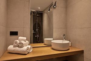 y baño con lavabo y ducha con toallas. en Old town, Splantzia modern house, en La Canea