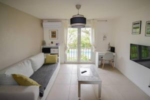 a living room with a couch and a table at Pompignane avec parking gratuit in Montpellier
