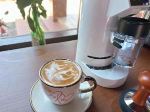 a cup of coffee sitting on a wooden table at Chandala Hotel in Thakhek