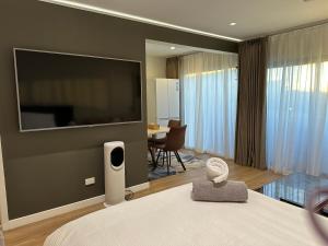 a bedroom with a large flat screen tv on a wall at Beautiful Lakeview Apartment in Taupo