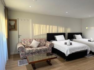 a room with a couch and a bed and a chair at Beautiful Lakeview Apartment in Taupo