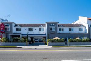 a building on the side of the road with a street at Ramada by Wyndham Redondo Beach in Redondo Beach
