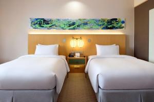 Postel nebo postele na pokoji v ubytování DoubleTree by Hilton Melaka