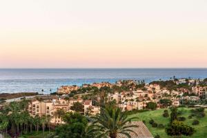 米哈斯科斯塔Wyndham Grand Costa del Sol的日落时分享有城市和大海的景致